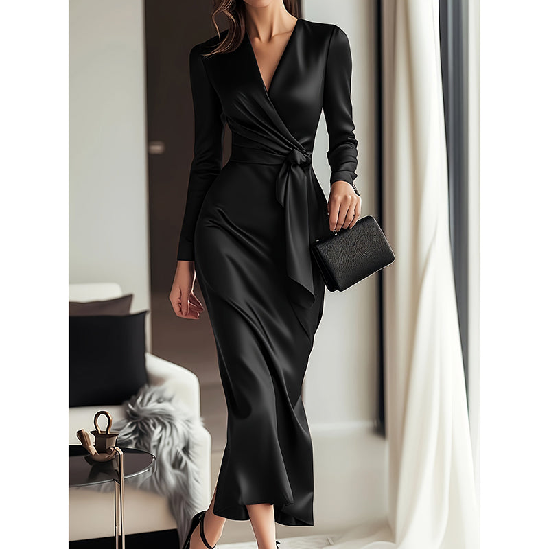 Woman in a black dress holding a clutch in an indoor setting