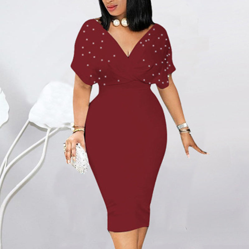 Woman wearing a burgundy dress with star embellishments on a plain background