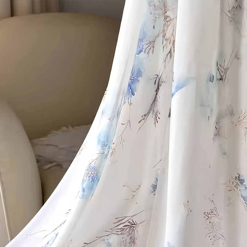 Floral patterned curtain with a beige chair in the background