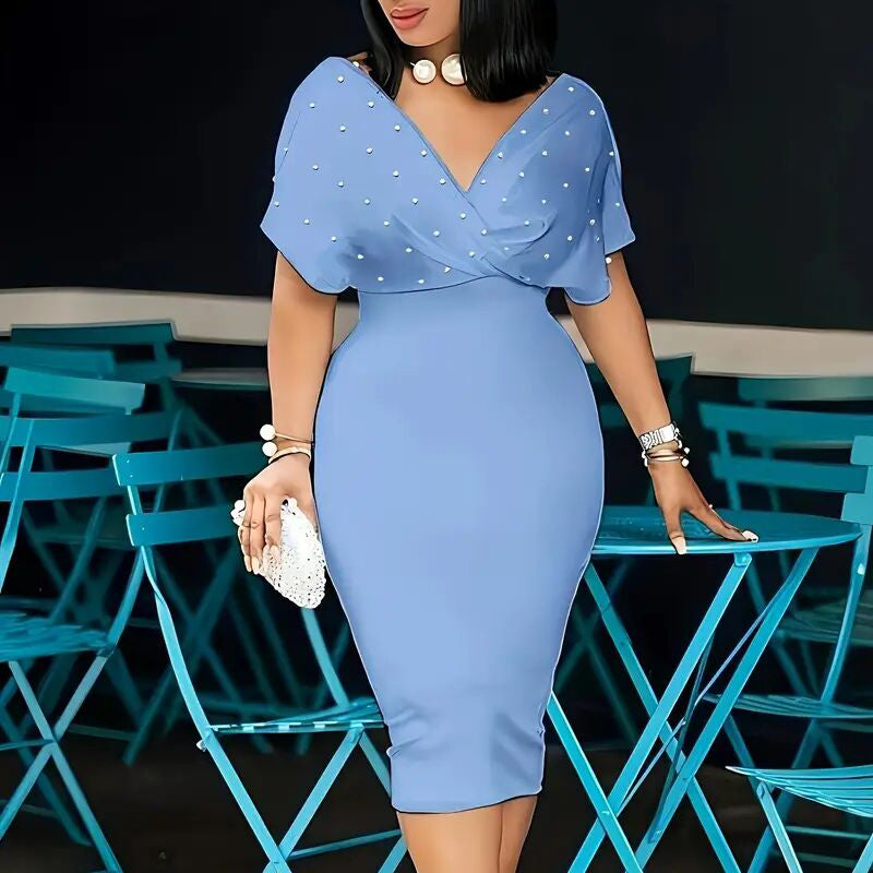 Woman in a blue dress standing among blue chairs and tables.