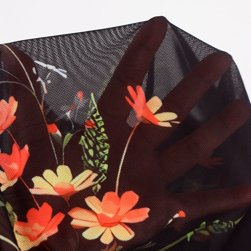 Close-up of a floral-patterned glove with red and orange flowers on a dark background