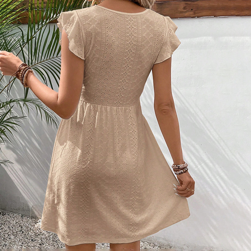 Beige dress worn by a person with a neutral background