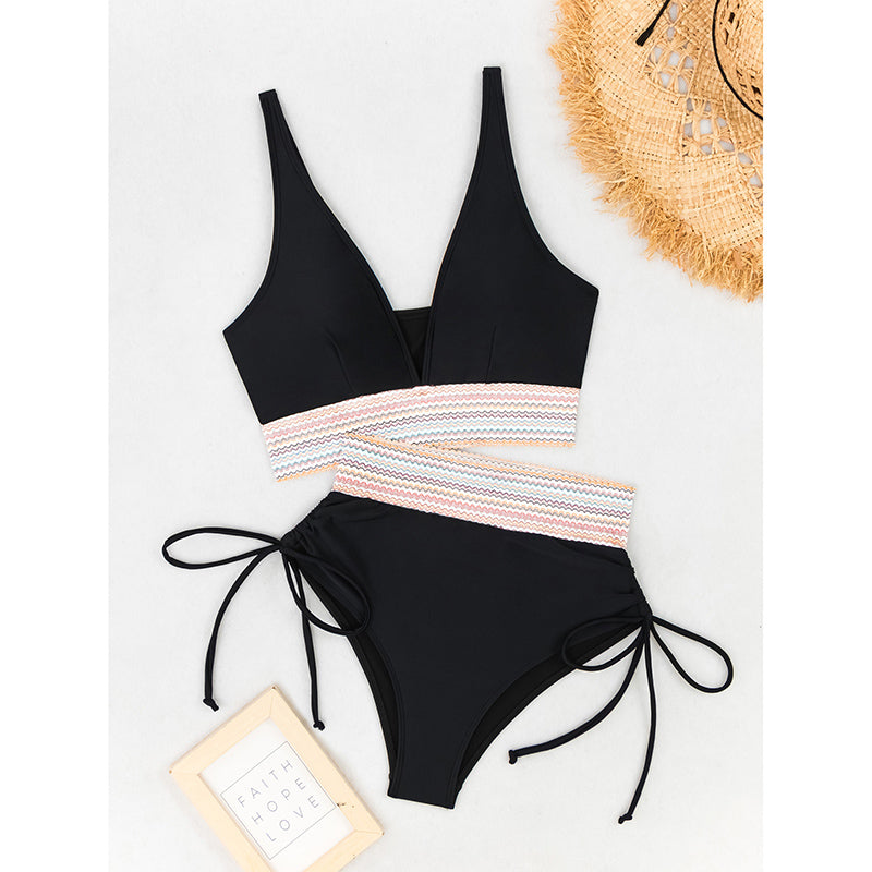 Black bikini set with a colorful striped top on a white background