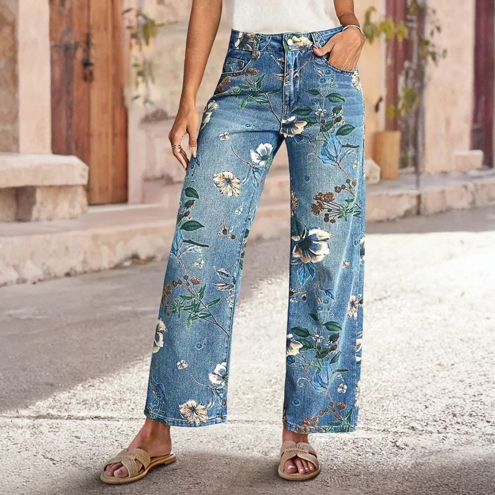 Person wearing floral-patterned jeans standing on a street.