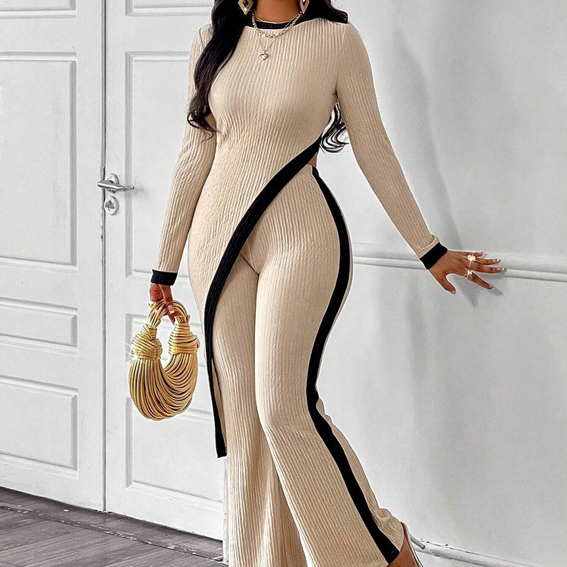 Woman wearing a beige ribbed dress with black trim against a white background