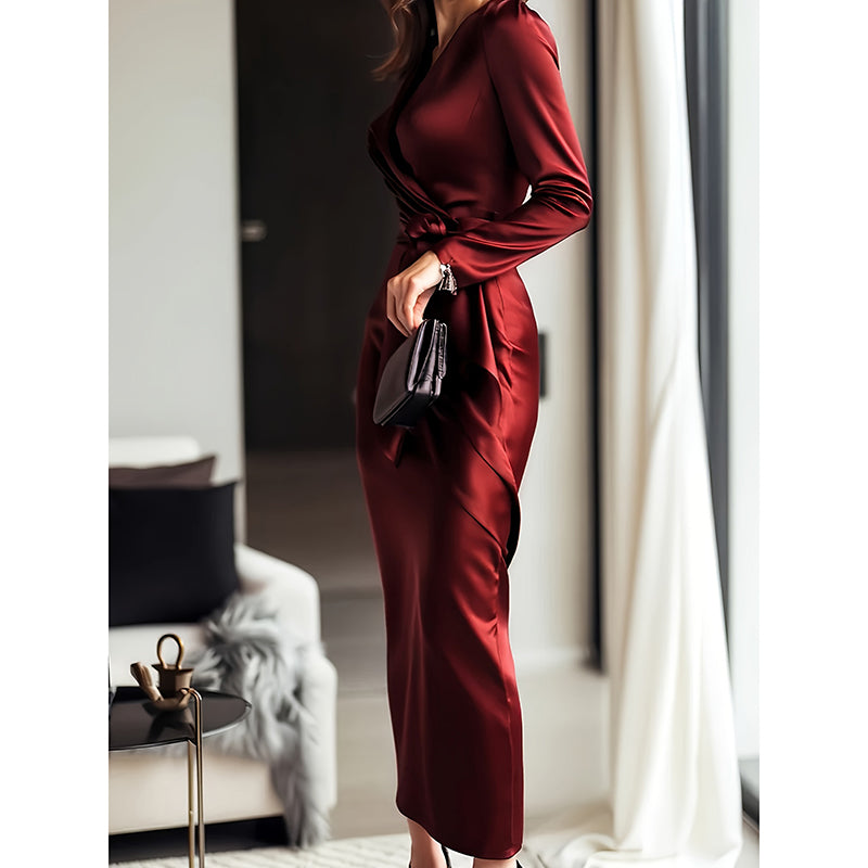 Person wearing a burgundy dress holding a black clutch in an indoor setting.