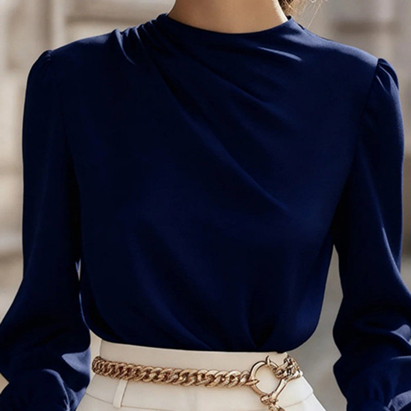 Navy blue long-sleeve top worn by a person with a blurred background